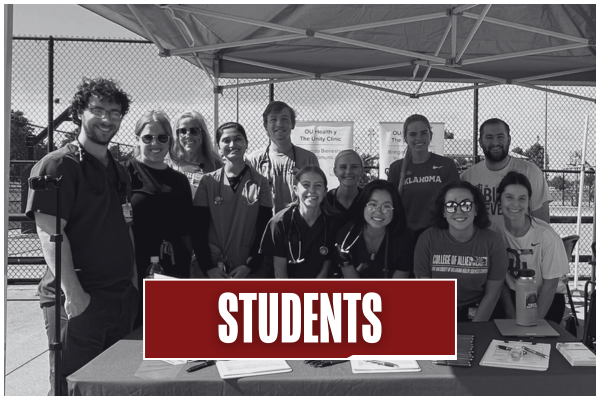 Black and white image of students smiling gathered around an Unity Clinic outreach booth. Title on image says "Students".