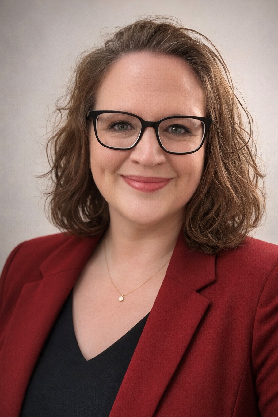 A professional picture of a woman wearing a red blazer